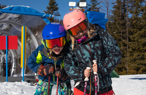 Two young female skiiers smiling.