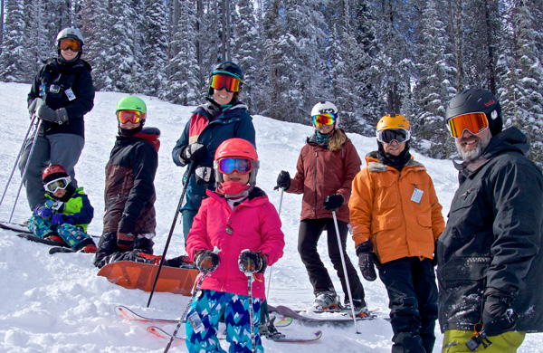 Group of adults and kids skiing on the mountain.