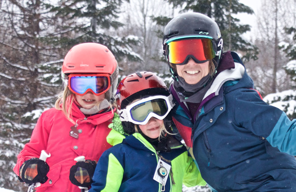 Woman and two kids smiling.