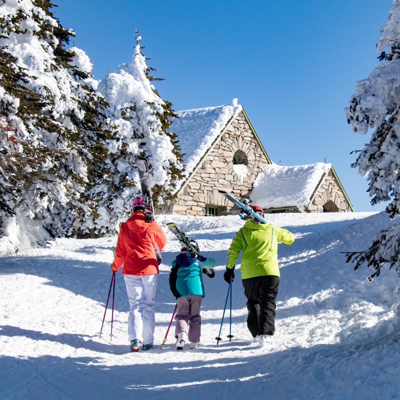 Family of skiers walking up to the summit lodge at Mount Spokane.